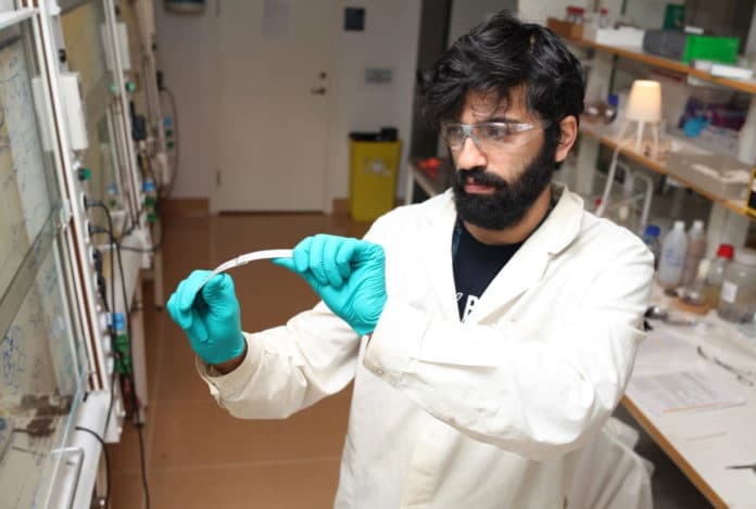 M. Sc. Mohammad Morsali one of the researchers behind the study shows adhesive strength of the lignin based material by bending the bonded aluminum plates.