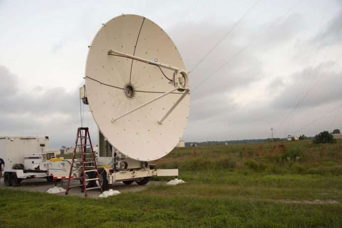 A microwave dish transmitter is pointed toward a rectifying antenna in part of the Safe and Continuous Power Beaming – Microwave (SCOPE-M) demonstration.