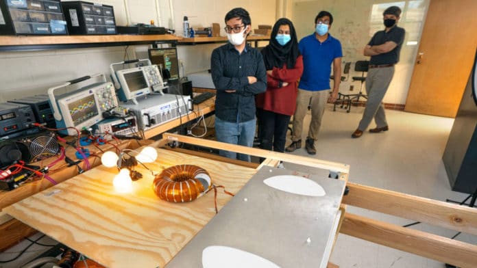 Doctoral students, from left, Sounak Maji and Maida Farooq and postdoctoral researcher Sreyam Sinha work to develop a wireless power transfer system in the lab.