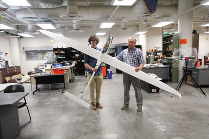 Aerospace engineering doctoral student Adrien Bouskela (left) and aerospace and mechanical engineering professor Sergey Shkarayev hold an experimental sailplane.