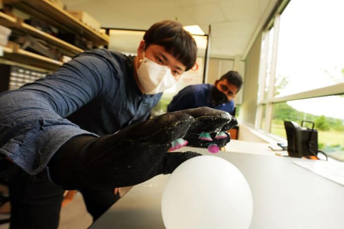 Chanhong Lee and Ravi Tutika test the Octa-Glove in the lab of Michael Bartlett.