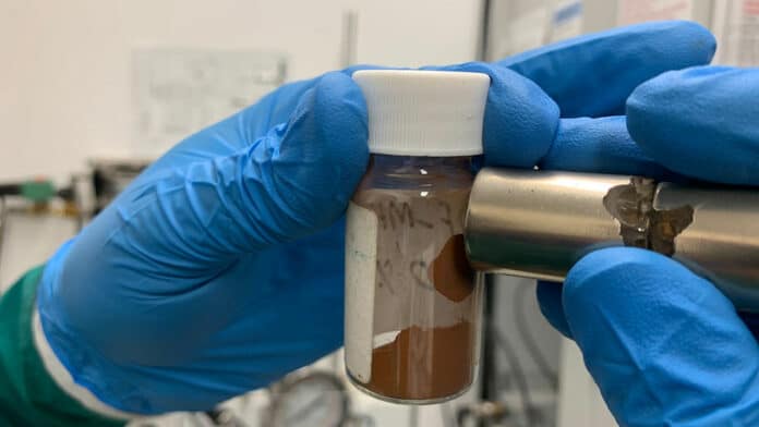 A magnet attracts the material that the team used to make adsorbents that remove microplastics and dissolved pollutants from water.