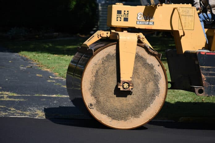 A vibratory roller compacts the road bed.