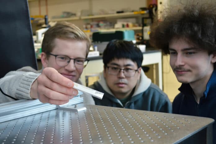 In the above image, University of Minnesota students Matthew Stein, Yujie Luo, and Sam Keller interact with an object that has a metamaterial surface.