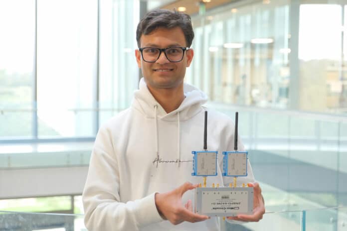 Ish Kumar Jain holding a small prototype of a new programmable antenna array dubbed the “delay-phased array.”