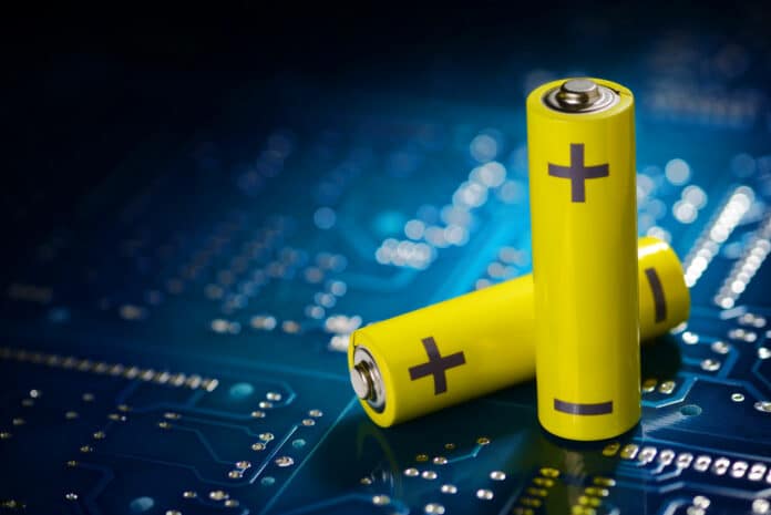 Yellow mignon AA batteries on the blue printed circuit board. Macro shot