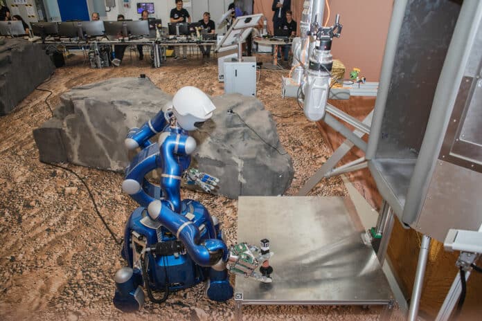 A sample canister is placed on the lander by the Rollin' Justin robot during the initial Surface Avatar test campaign at DLR Oberpfaffenhofen.