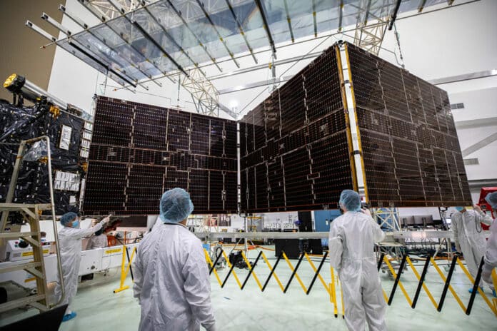 Technicians begin to retract one of the two solar arrays attached to NASA’s Psyche spacecraft.