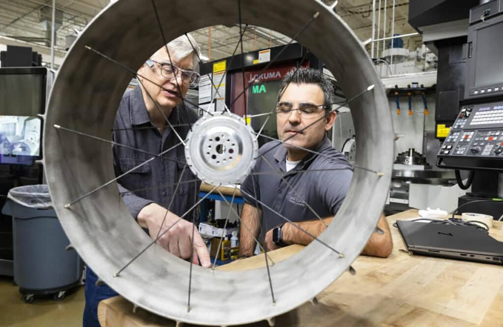 NASA mechanical design engineer Richard Hagen, left, and ORNL researcher Michael Borish inspect a lunar rover wheel prototype that was 3D printed at the Manufacturing Demonstration Facility.