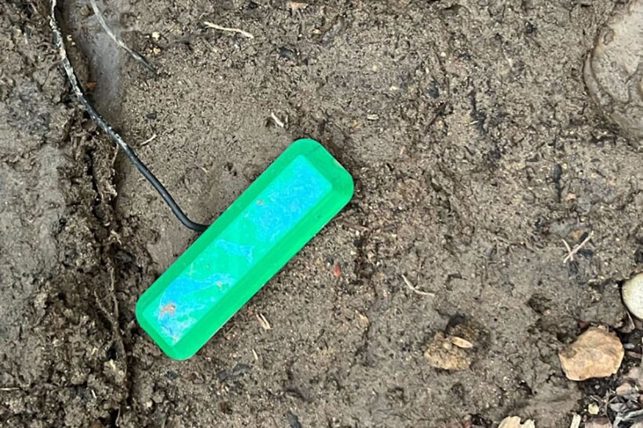 The device's 3D-printed cap sticks out of the ground.
