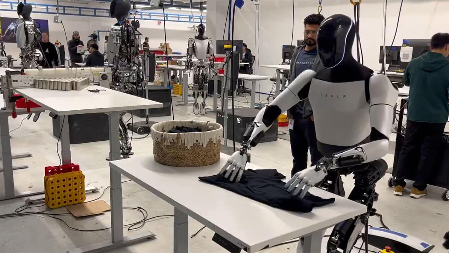 Elon Musk shares video of Tesla Optimus humanoid folding a shirt.