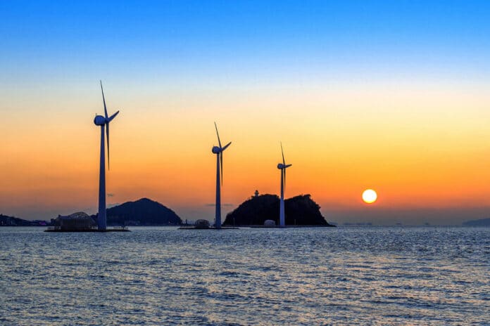 Wind turbines generating electricity at sunset