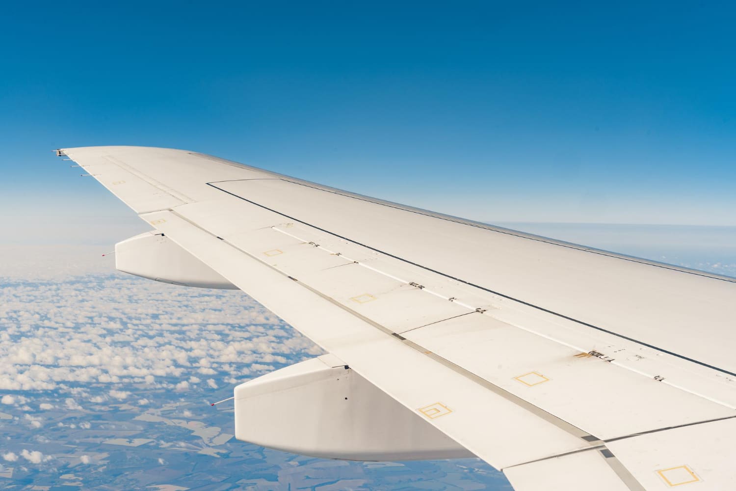 Wing of passenger plane above the land view from inside