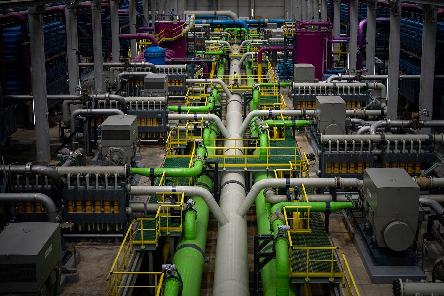 A worker walks over the pipeline that transports seawater to filters at Europe's largest desalination plant for drinking water located in Barcelona, Spain.