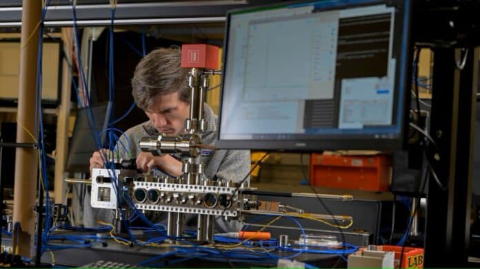 Jonathan Kwolek, Ph.D., a research physicist from the U.S. Naval Research Laboratory (NRL) Quantum Optics Section attaches fiber-optic cables to deliver light into the compact laser-delivery system.